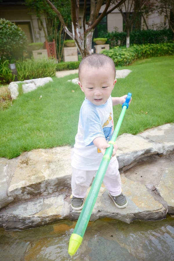 Jeu d'enfants dans le jardin avec des waterguns photos libres de droits Jeu d'enfants dans le jardin avec des waterguns photos libres de droits
