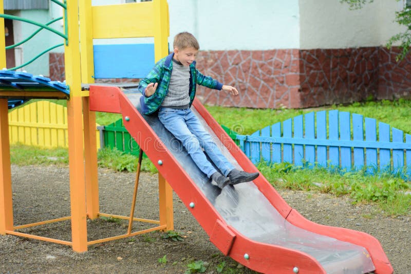 Jeu d'enfants drôle sur un terrain de jeu du ` s d'enfants photos stock Jeu d'enfants drôle sur un terrain de jeu du ` s d'enfants photos stock