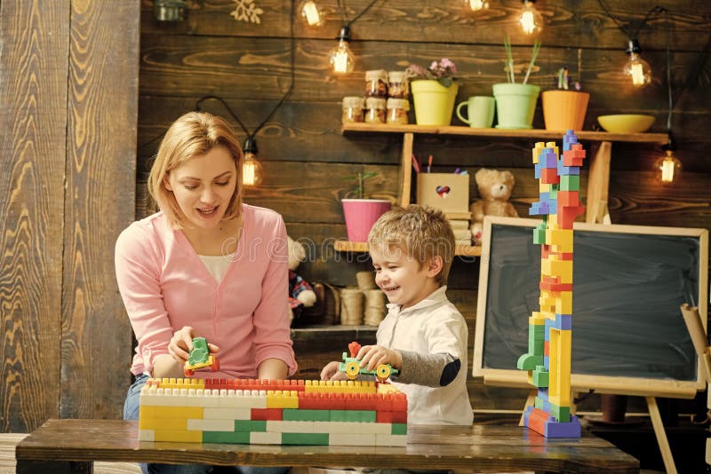 Jeu de mère et de fils avec des blocs de constructeur Maman et enfant emballant avec les voitures en plastique Maman parlant à so photos stock Jeu de mère et de fils avec des blocs de constructeur Maman et enfant emballant avec les voitures en plastique Maman parlant à so photos stock