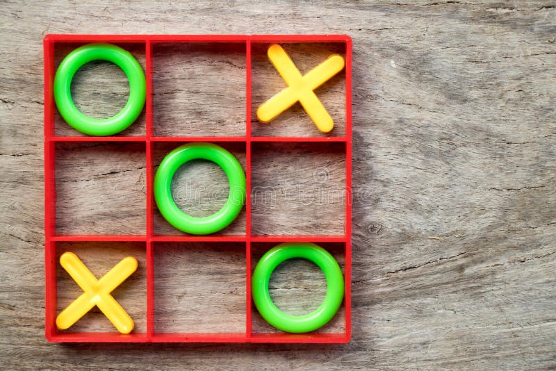 jeu de soci?t? de Tic-TAC-orteil avec de l'O vert et le X jaune dans le cadre rouge sur le fond en bois photographie stock jeu de soci?t? de Tic-TAC-orteil avec de l'O vert et le X jaune dans le cadre rouge sur le fond en bois photographie stock