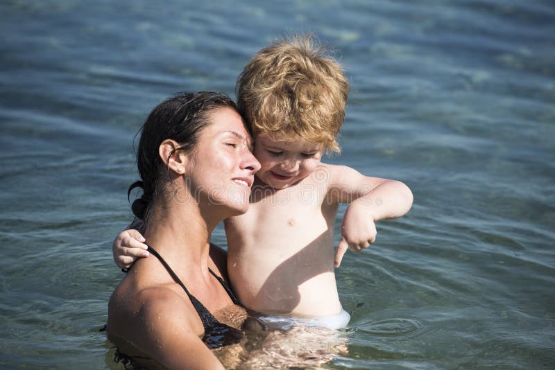 Jeu mignon de garçon d'enfant avec de l'eau dans l'océan, mer Concept de maternit? La mère porte le fils dans des mains, enfant d photographie stock Jeu mignon de garçon d'enfant avec de l'eau dans l'océan, mer Concept de maternit? La mère porte le fils dans des mains, enfant d photographie stock