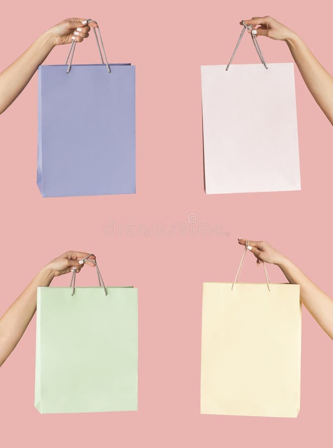 Jeune acheteur qui tient les sacs à provisions de papier de couleurs pastel sur le gros plan rose de fond. Liaison avec le vide photographie stock libre de droits