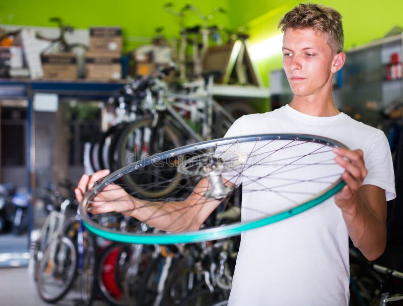 Jeune acheteur tenant la roue de vélo photo libre de droits