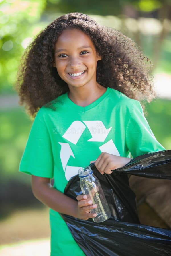 Jeune activiste environnemental souriant à l'appareil-photo prenant des déchets photographie stock