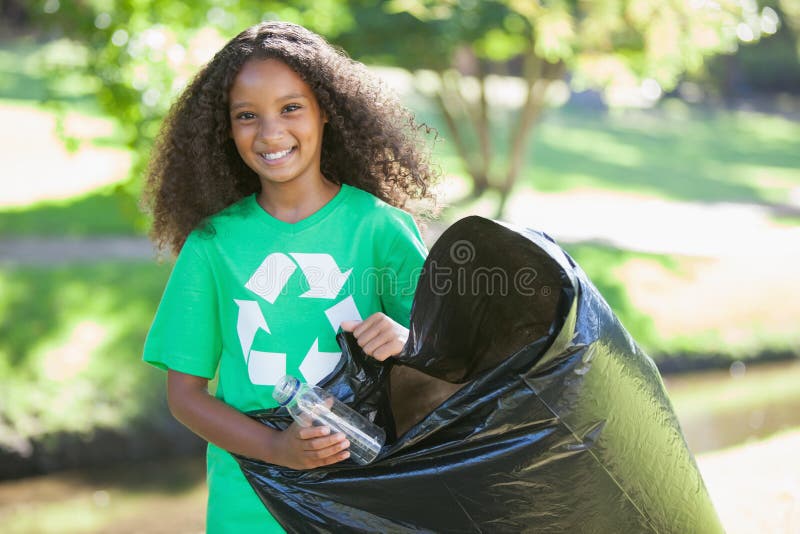 Jeune activiste environnemental souriant à l'appareil-photo prenant des déchets photo libre de droits