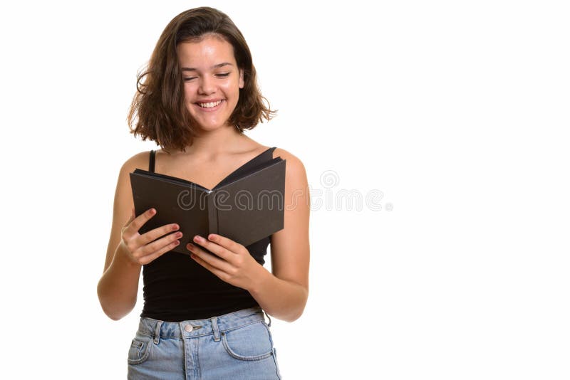 Jeune adolescente caucasienne heureuse souriant et livre de lecture photo stock Jeune adolescente caucasienne heureuse souriant et livre de lecture photo stock