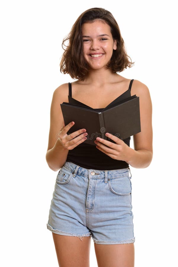 Jeune adolescente caucasienne heureuse souriant tout en tenant le livre images stock Jeune adolescente caucasienne heureuse souriant tout en tenant le livre images stock