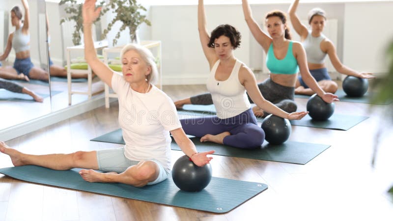 Jeune adulte hispanique passionnée de fitness groupe participant Pilates session dans un studio lumineux banque de vidéos