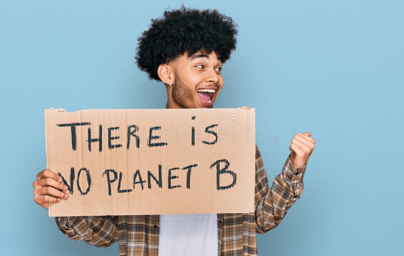 Jeune afro-américain avec des cheveux afro tenant il n'y a pas de planète b bannière pointant le pouce sur le côté souriant heureu images stock