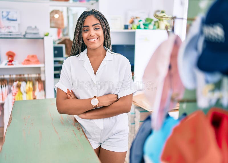 Jeune afro-américaine souriante heureuse de travailler à la caisse dans la boutique images libres de droits