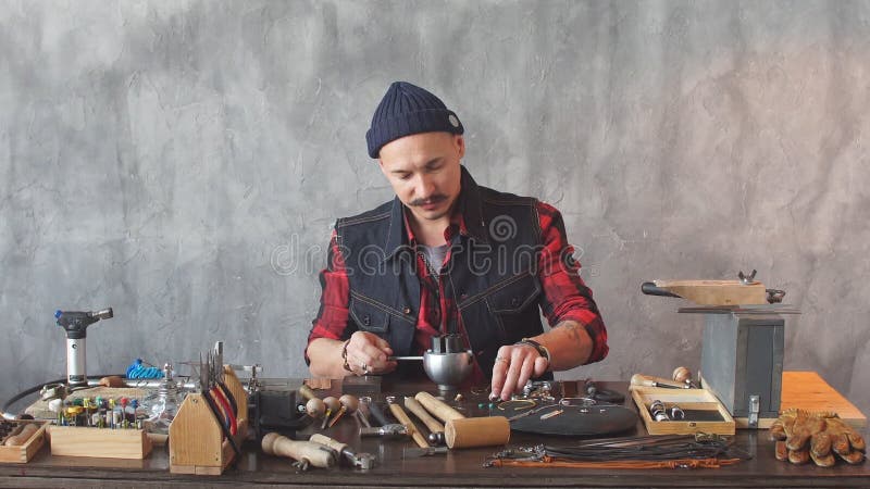 Jeune artisan ambitieux fixant un bijou dans la boucle d'oreille