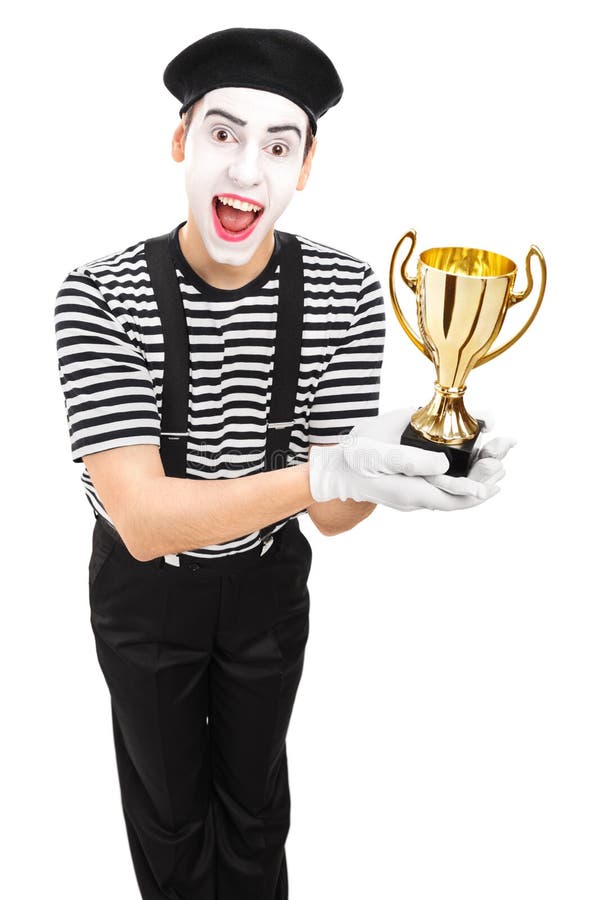 Jeune artiste masculin de pantomime présent un trophée photos libres de droits Jeune artiste masculin de pantomime présent un trophée photos libres de droits