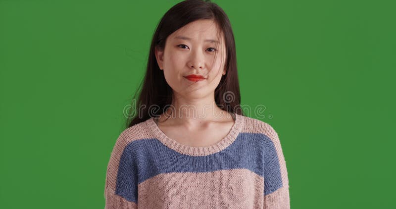 Jeune asiatique confiante debout à l'intérieur du studio d'écran vert banque de vidéos