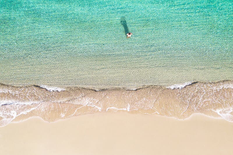 Jeune athlète en maillot de bain sortent de la mer sur la côte de plage de sable. été. vue depuis le haut. ordinateur à vue supéri image libre de droits
