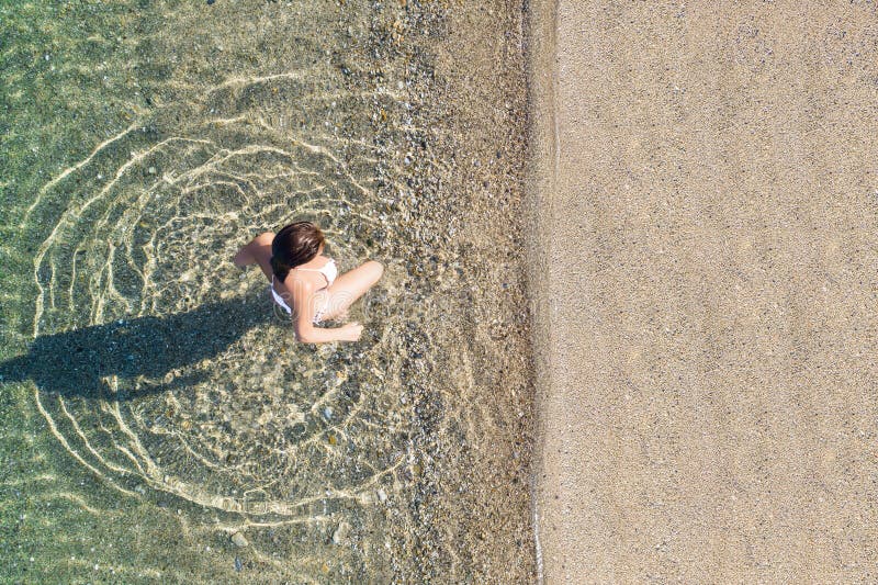 Jeune athlète en maillot de bain sortent de la mer sur la côte de plage de sable. été. vue depuis le haut. ordinateur à vue supéri images stock