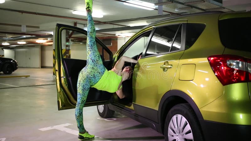 Jeune athlète lève la jambe en utilisant la voiture comme banque de vidéos