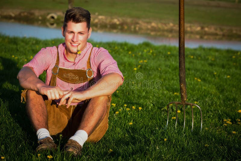 Jeune bavarois blond assis dans l'herbe