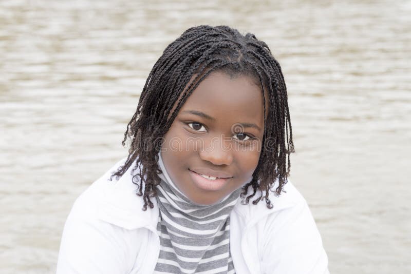 Jeune beauté d'Afro près de l'eau image libre de droits Jeune beauté d'Afro près de l'eau image libre de droits