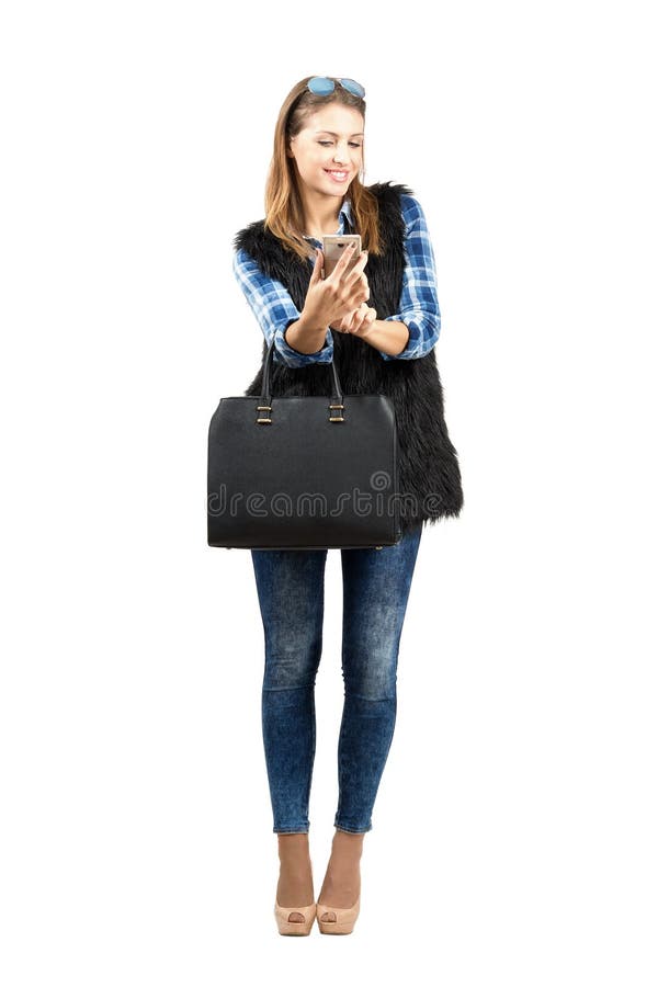 Jeune beauté à la mode à la mode vérifiant son téléphone portable photo stock Jeune beauté à la mode à la mode vérifiant son téléphone portable photo stock