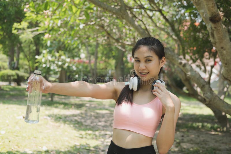jeune belle femme asiatique d'athlète de forme physique tenant le wat potable photo libre de droits jeune belle femme asiatique d'athlète de forme physique tenant le wat potable photo libre de droits