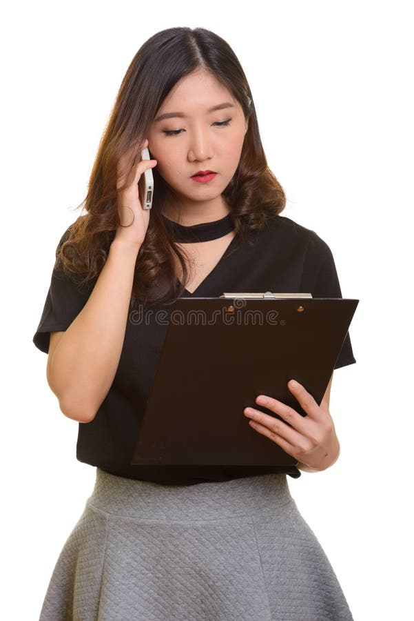 Jeune belle femme d'affaires asiatique parlant sur le whil de téléphone portable images stock Jeune belle femme d'affaires asiatique parlant sur le whil de téléphone portable images stock