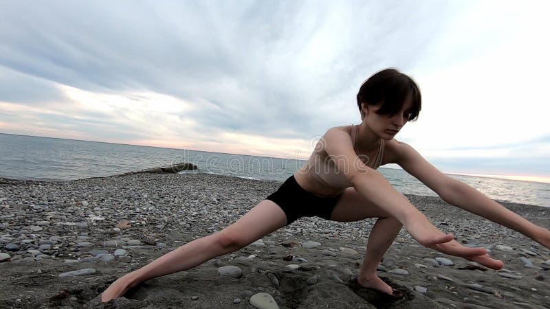 Jeune belle femme faisant étirant l'exercice au bord de la mer Style de vie sain Concept de forme physique