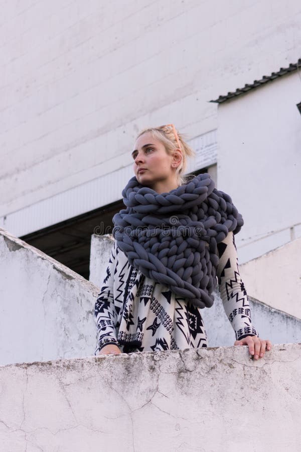 Jeune belle fille blonde de mode utilisant la veste noire et blanche aztèque et l'écharpe grise tricotée de gilet Équipement de f image libre de droits Jeune belle fille blonde de mode utilisant la veste noire et blanche aztèque et l'écharpe grise tricotée de gilet Équipement de f image libre de droits