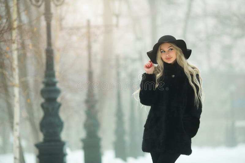 Jeune belle fille dans un manteau de fourrure noir images stock Jeune belle fille dans un manteau de fourrure noir images stock