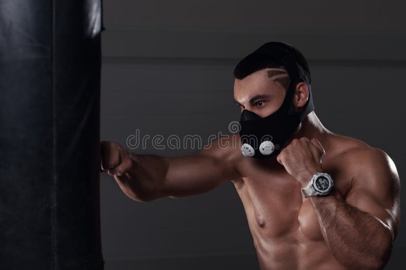 Jeune boxe musculaire d'homme dans le masque de haute altitude