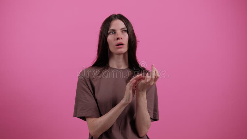 Jeune brune femme compte sur ses doigts. girl on rose studio fond pense à quelque chose. gens clips vidéos
