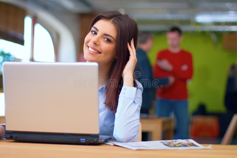 Jeune busineswoman se reposant dans le bureau avec l'ordinateur portable photos libres de droits Jeune busineswoman se reposant dans le bureau avec l'ordinateur portable photos libres de droits