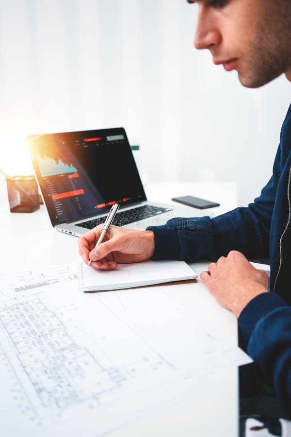 Jeune concepteur intelligent d'architecte travaillant au bureau moderne de studio avec le plan d'ordinateur et de modèle photos stock Jeune concepteur intelligent d'architecte travaillant au bureau moderne de studio avec le plan d'ordinateur et de modèle photos stock