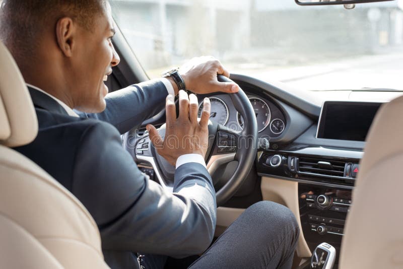 homme poussant le klaxon tout en conduisant assis d'une voiture de