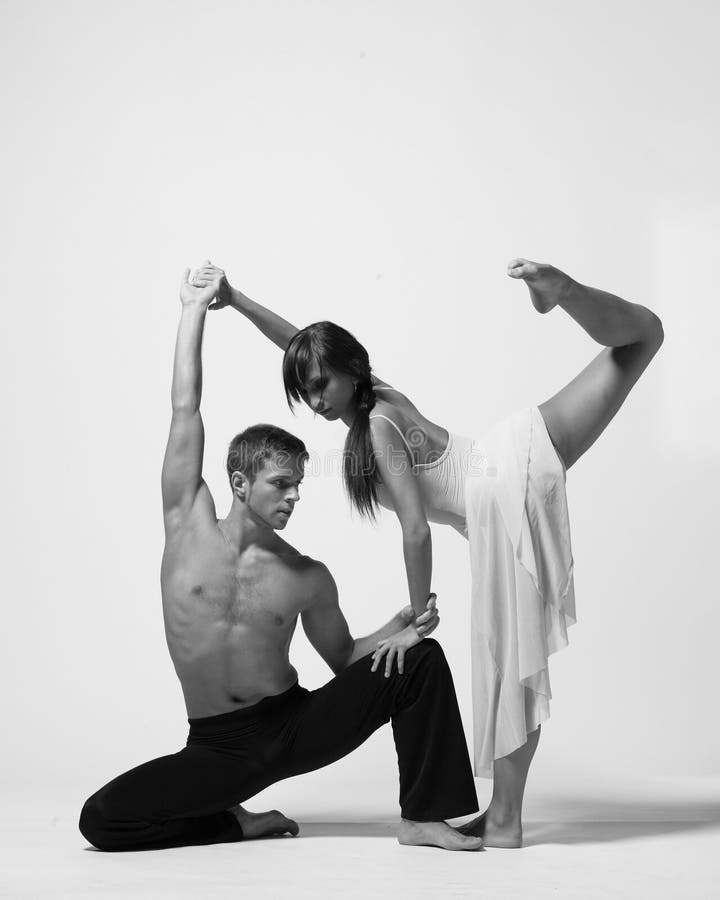 Jeune couple de danseurs de ballet modernes posant sur fond clair de studio