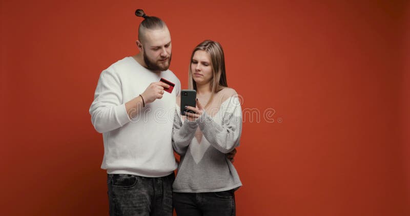Jeune couple femme et homme acheter en ligne en utilisant smartphone et carte de crédit. banque de vidéos