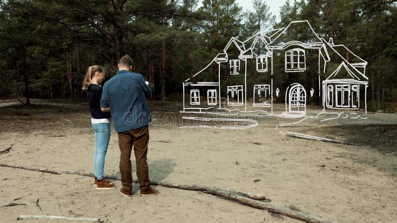 Jeune couple planifiant leur maison de rêve familiale sur un terrain acheté banque de vidéos
