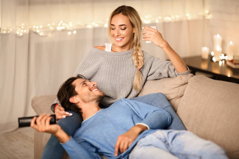 Jeune couple profitant des vacances d'hiver parler et regarder la télévision images libres de droits