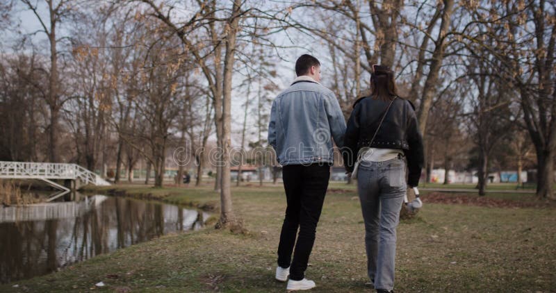 Jeune couple Profitez d'une promenade romantique à travers le parc au bord de la rivière banque de vidéos