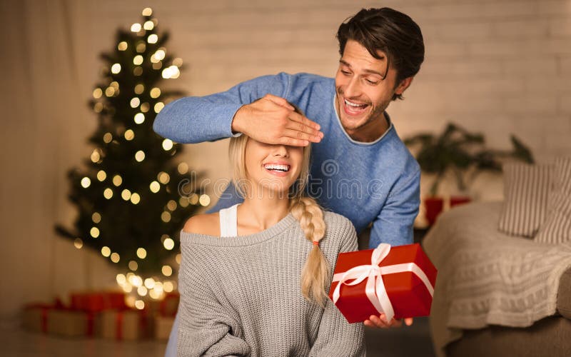 Jeune couple échangeant des cadeaux la veille de noël images libres de droits