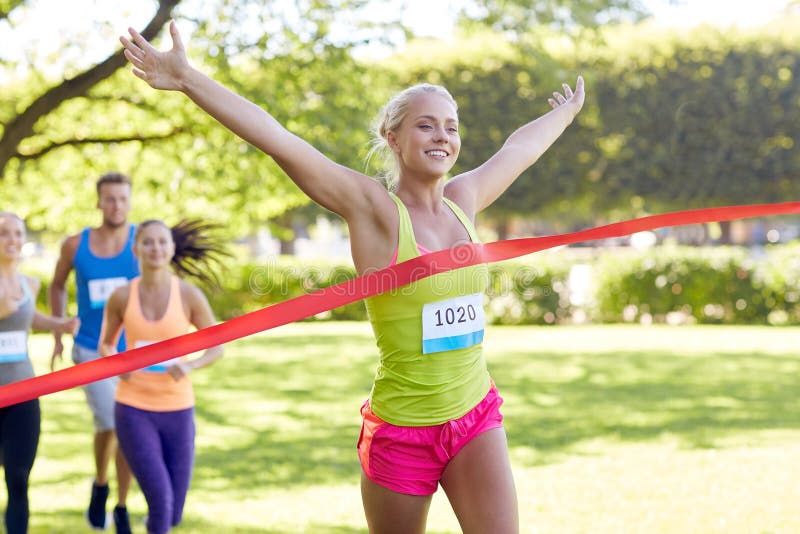 Jeune coureur féminin heureux gagnant sur la finition de course images libres de droits