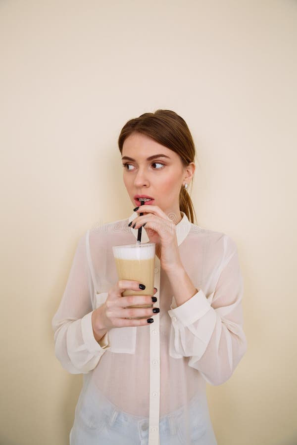 Jeune dame concentrée posant tout en tenant le café photos libres de droits