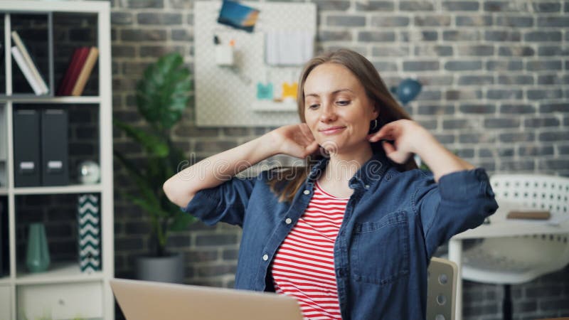 Jeune dame dactylographiant au travail utilisant l'ordinateur portable se reposant alors de retour dans la chaise confortable banque de vidéos