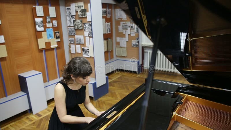 Jeune dame douée heureuse jouant le piano à queue clips vidéos
