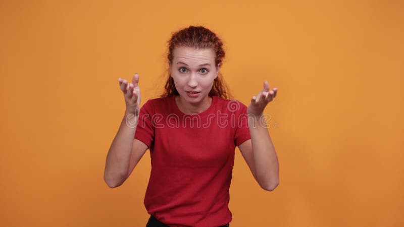 Jeune dame effrayée en chemise rouge tenant la main sur la tête
