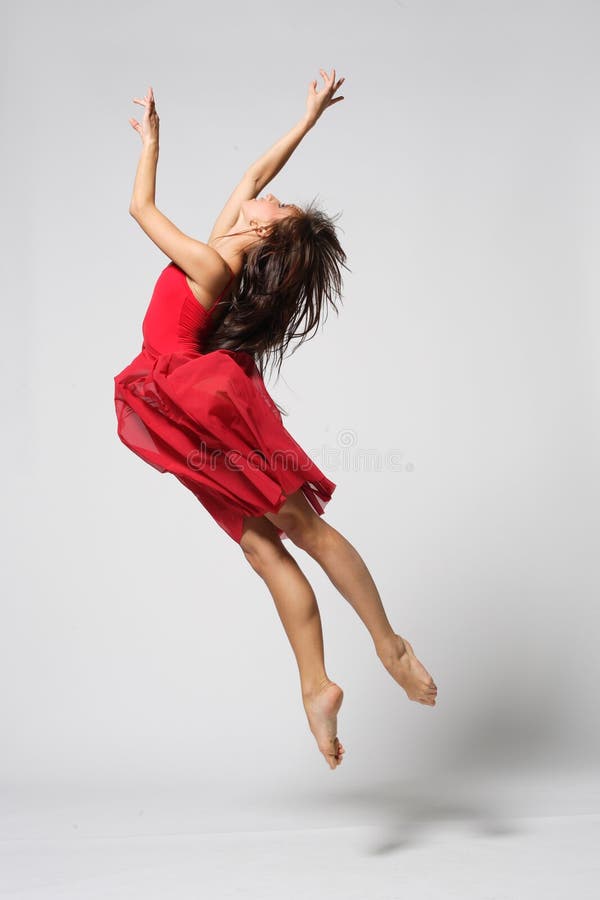 Jeune danseuse de ballet moderne dansant sur fond studio gris