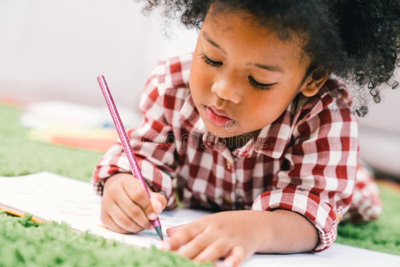 Jeune dessin ou peinture mignon de fille d'enfant d'Afro-américain avec le crayon coloré photos libres de droits