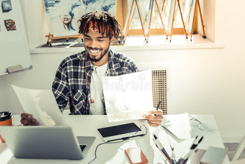 Jeune dessinateur d'intérieurs se sentant extrêmement satisfaisant avec son travail photos stock Jeune dessinateur d'intérieurs se sentant extrêmement satisfaisant avec son travail photos stock