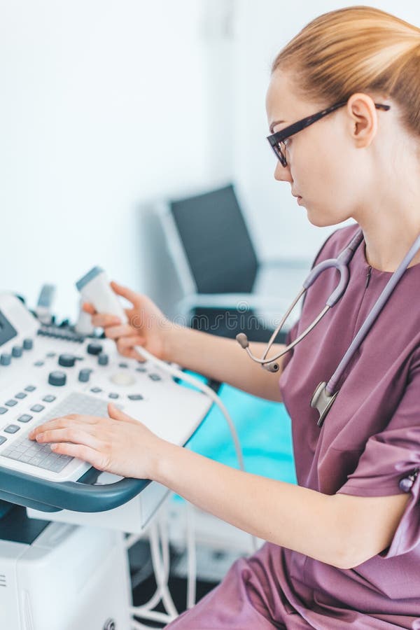 Jeune docteur féminin de londe avec les verres noirs Scanner d'ultrason dans les mains d'un docteur diagnose ?chographie photos stock Jeune docteur féminin de londe avec les verres noirs Scanner d'ultrason dans les mains d'un docteur diagnose ?chographie photos stock