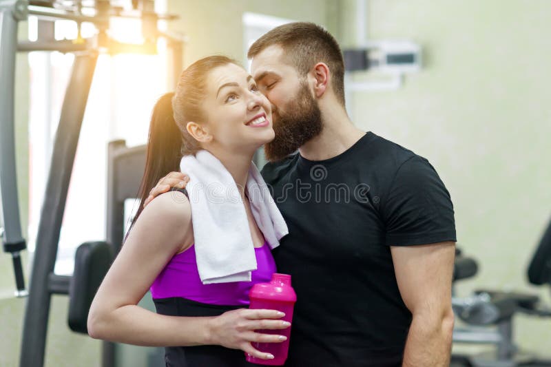 Jeune embrassement parlant de sourire heureux d'homme et de femme dans le gymnase Sport, formation, famille et mode de vie sain photo libre de droits Jeune embrassement parlant de sourire heureux d'homme et de femme dans le gymnase Sport, formation, famille et mode de vie sain photo libre de droits
