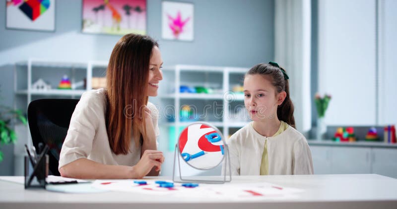 Jeune enfant apprend à parler avec des orthophonistes assistance images stock
